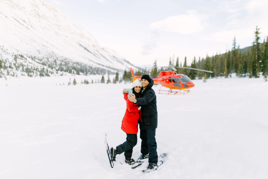 Couple taking a selfie in front of helicopter