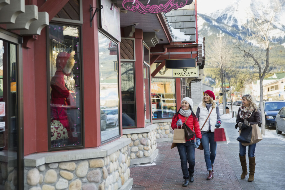 Women shopping and walking along a sidewalk in downtown Canmore