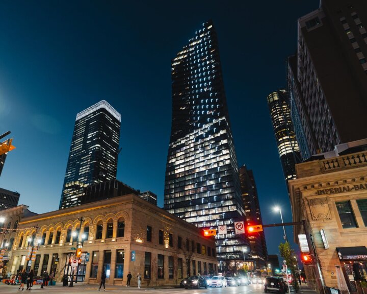 A street-level view of downtown Calgary at night along Stephen Avenue.