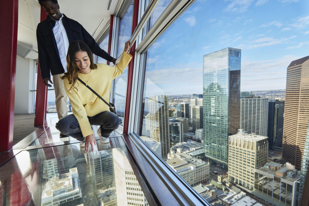 couple standing on the glass floor of the Calgary Tower observation deck