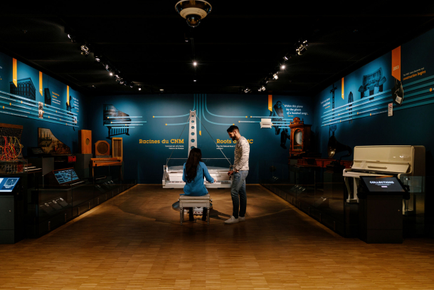 couple interacting with musical instrument exhibits at Studio Bell