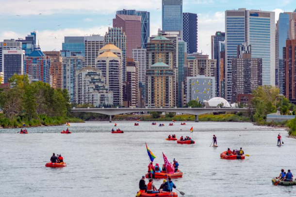 People rafting down the Bow with the city skyline in the background.